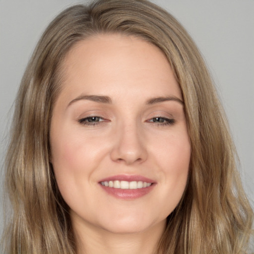 Joyful white young-adult female with long  brown hair and brown eyes