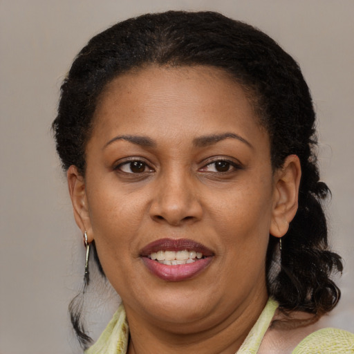 Joyful black adult female with medium  brown hair and brown eyes