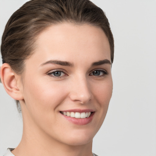 Joyful white young-adult female with medium  brown hair and grey eyes