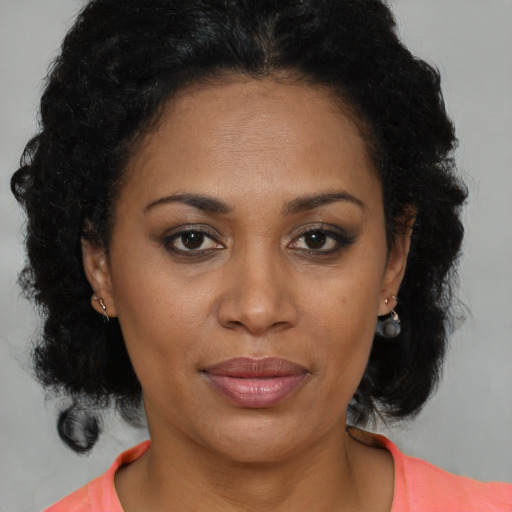 Joyful black adult female with medium  brown hair and brown eyes