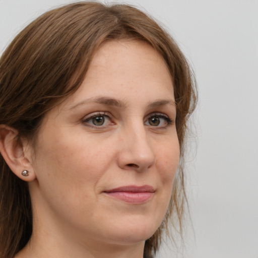 Joyful white adult female with long  brown hair and grey eyes