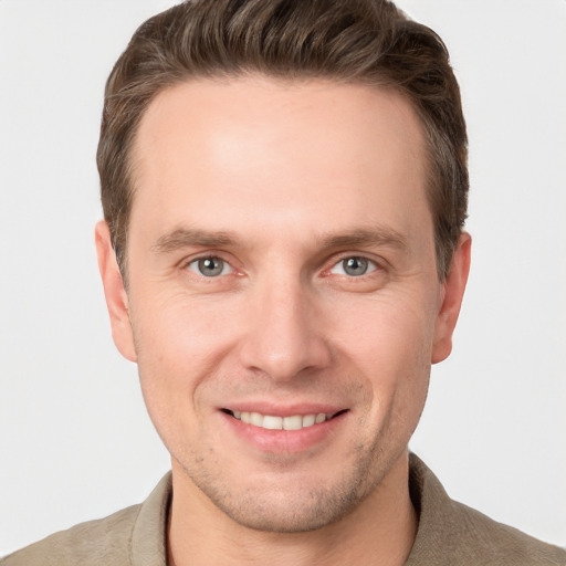 Joyful white young-adult male with short  brown hair and grey eyes