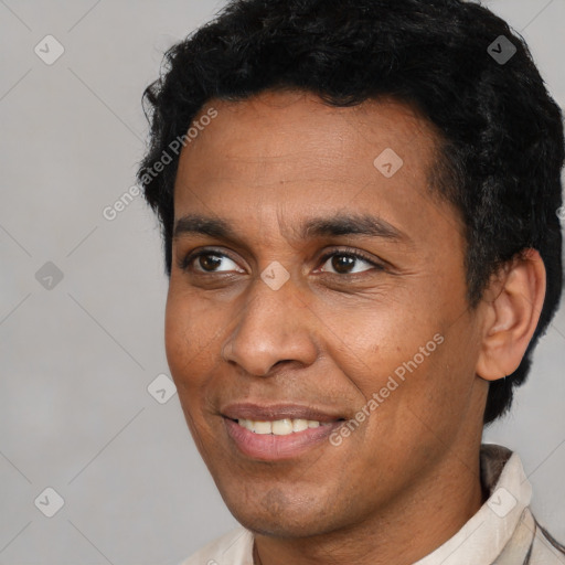 Joyful latino adult male with short  black hair and brown eyes