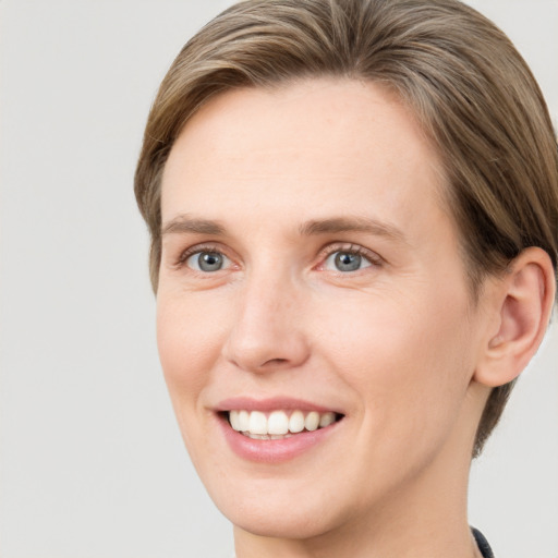 Joyful white young-adult female with short  brown hair and grey eyes