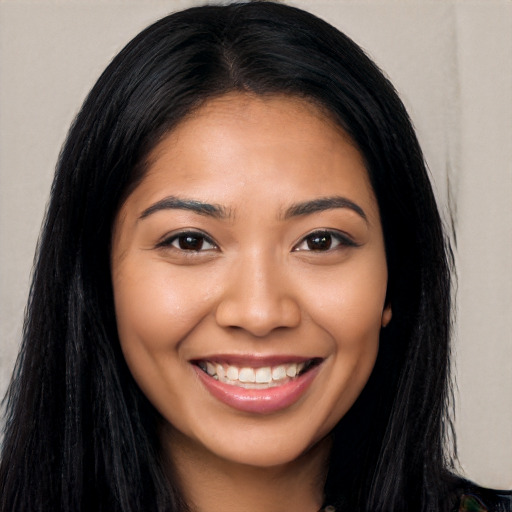 Joyful latino young-adult female with long  black hair and brown eyes