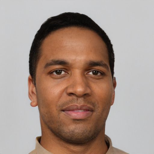 Joyful black young-adult male with short  black hair and brown eyes