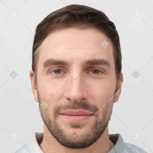 Joyful white young-adult male with short  brown hair and grey eyes