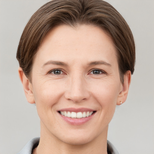 Joyful white young-adult female with short  brown hair and grey eyes