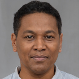 Joyful latino adult male with short  brown hair and brown eyes