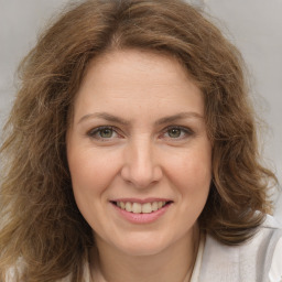 Joyful white young-adult female with long  brown hair and green eyes