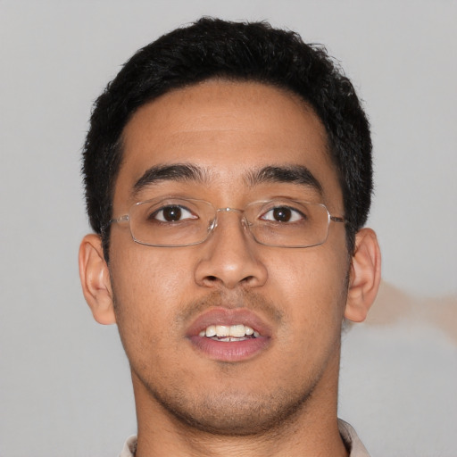 Joyful latino young-adult male with short  brown hair and brown eyes