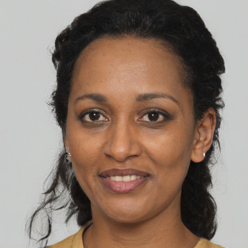 Joyful black adult female with medium  black hair and brown eyes