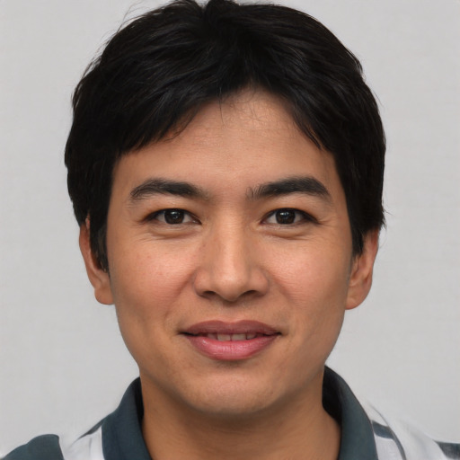 Joyful asian young-adult male with short  black hair and brown eyes