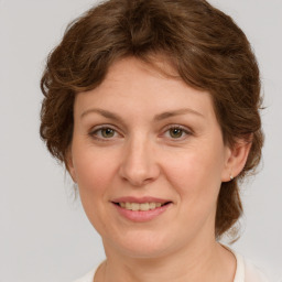 Joyful white young-adult female with medium  brown hair and green eyes