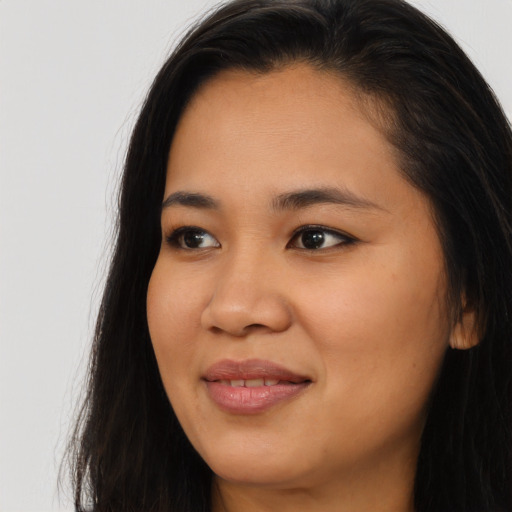 Joyful asian young-adult female with long  brown hair and brown eyes