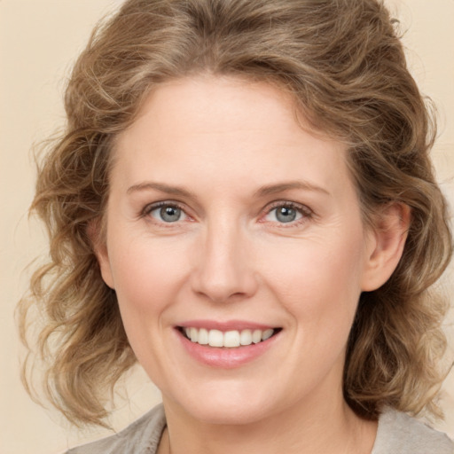 Joyful white young-adult female with medium  brown hair and green eyes