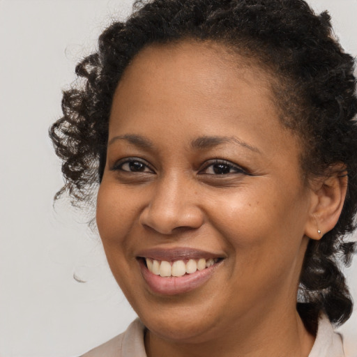 Joyful black young-adult female with medium  brown hair and brown eyes