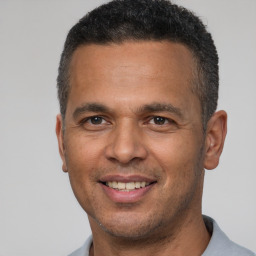 Joyful latino adult male with short  brown hair and brown eyes