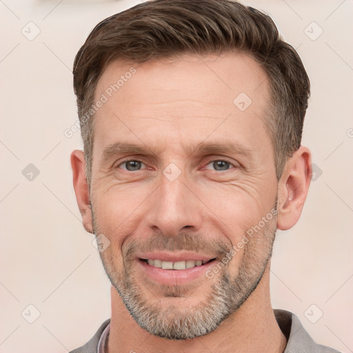 Joyful white adult male with short  brown hair and grey eyes