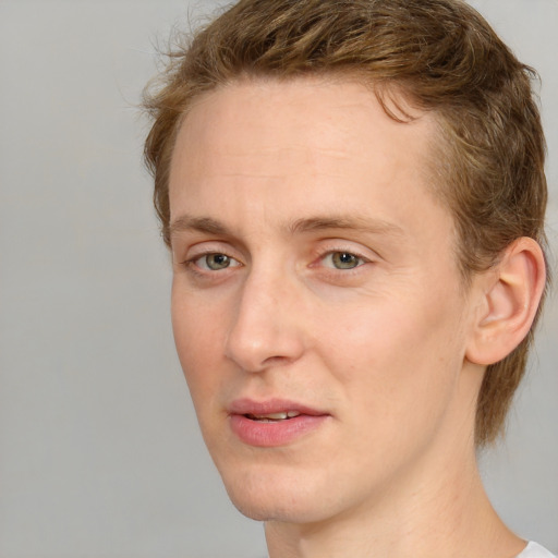 Joyful white young-adult male with medium  brown hair and green eyes