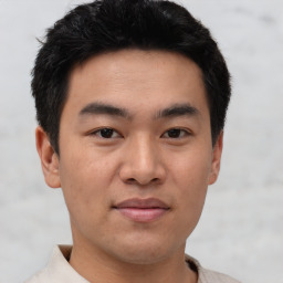 Joyful asian young-adult male with short  black hair and brown eyes