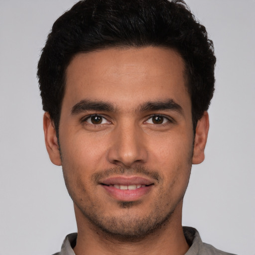 Joyful white young-adult male with short  black hair and brown eyes