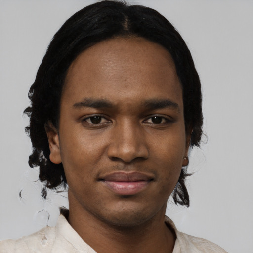 Joyful black young-adult male with medium  black hair and brown eyes