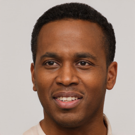 Joyful black young-adult male with short  black hair and brown eyes