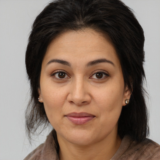 Joyful white adult female with long  brown hair and brown eyes