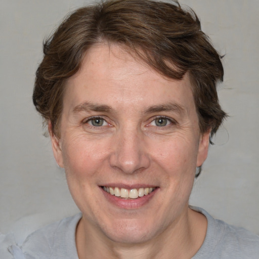 Joyful white adult female with short  brown hair and grey eyes