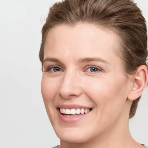 Joyful white young-adult female with short  brown hair and grey eyes