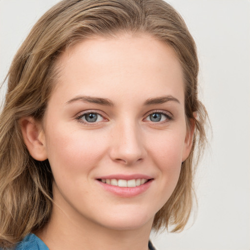 Joyful white young-adult female with long  brown hair and blue eyes