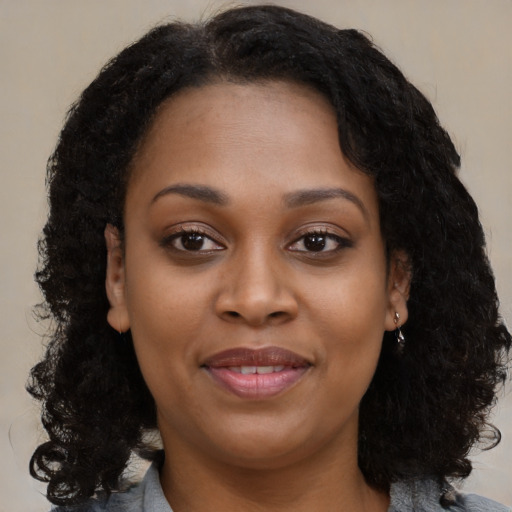 Joyful black young-adult female with medium  brown hair and brown eyes