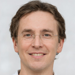 Joyful white adult male with short  brown hair and grey eyes