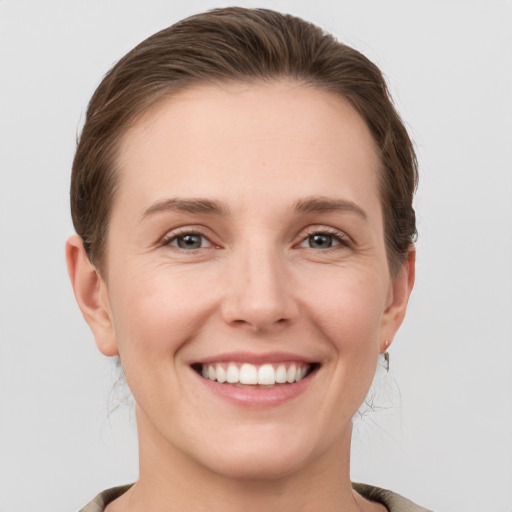 Joyful white young-adult female with short  brown hair and grey eyes