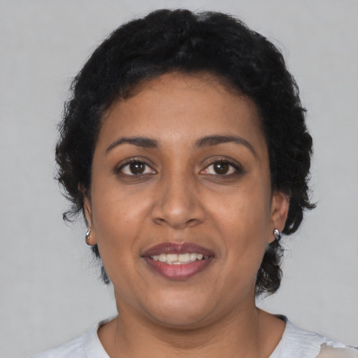 Joyful latino adult female with short  brown hair and brown eyes