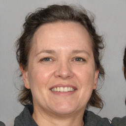 Joyful white adult female with medium  brown hair and blue eyes