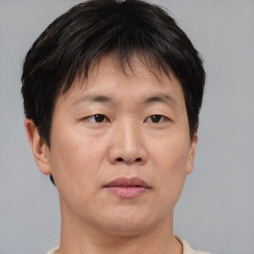 Joyful asian adult male with short  brown hair and brown eyes