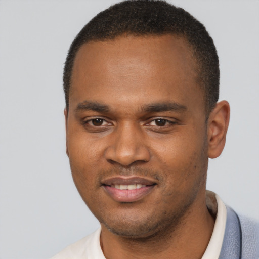Joyful black young-adult male with short  brown hair and brown eyes