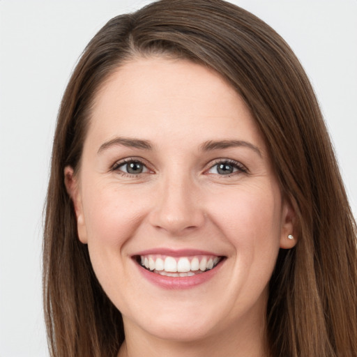 Joyful white young-adult female with long  brown hair and grey eyes