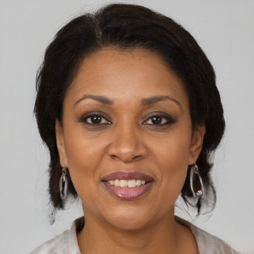 Joyful latino adult female with medium  brown hair and brown eyes