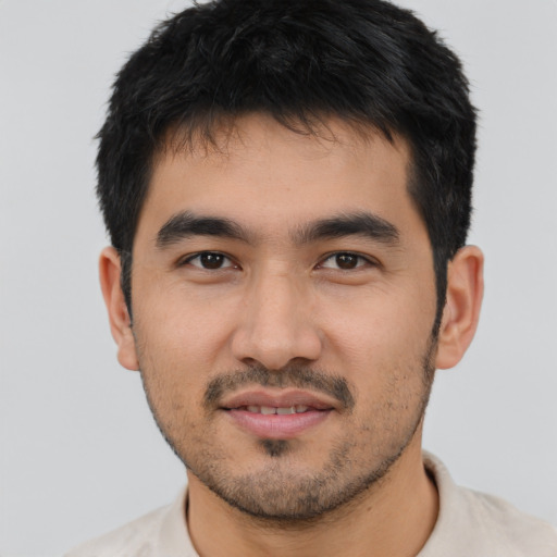 Joyful latino young-adult male with short  black hair and brown eyes