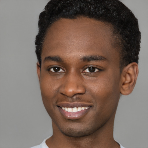 Joyful black young-adult male with short  brown hair and brown eyes