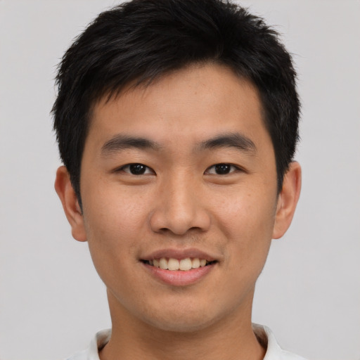 Joyful asian young-adult male with short  brown hair and brown eyes