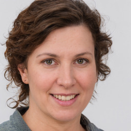 Joyful white young-adult female with medium  brown hair and green eyes