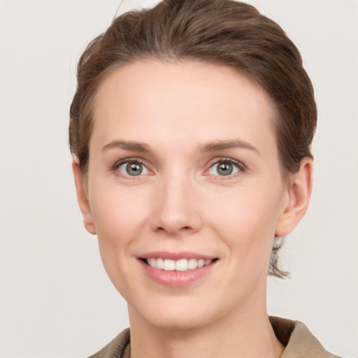 Joyful white young-adult female with short  brown hair and grey eyes