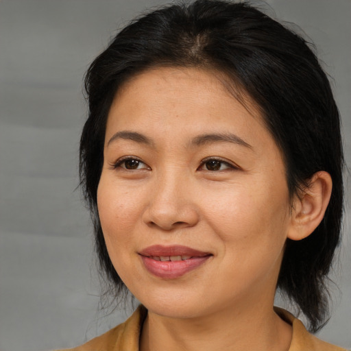 Joyful asian adult female with medium  brown hair and brown eyes