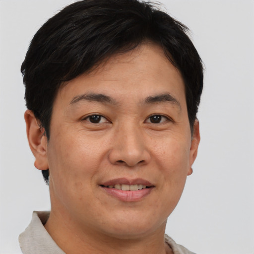 Joyful asian adult male with short  brown hair and brown eyes