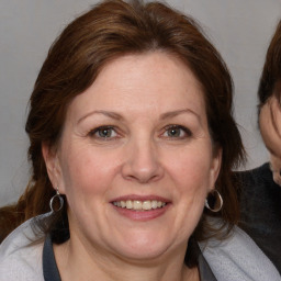 Joyful white adult female with medium  brown hair and blue eyes