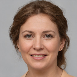 Joyful white adult female with medium  brown hair and grey eyes